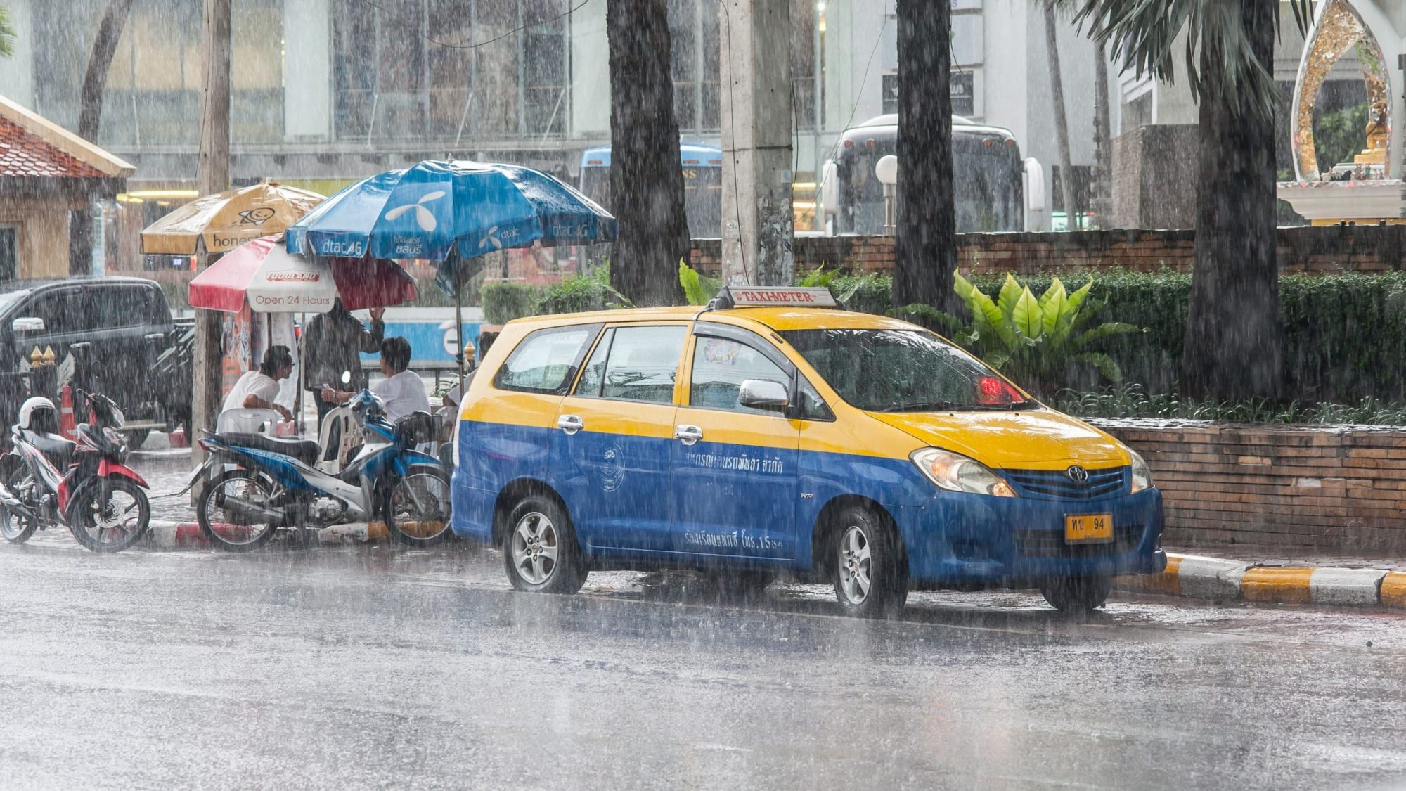 曼谷豪雨中停靠路旁的計程車與積水路面