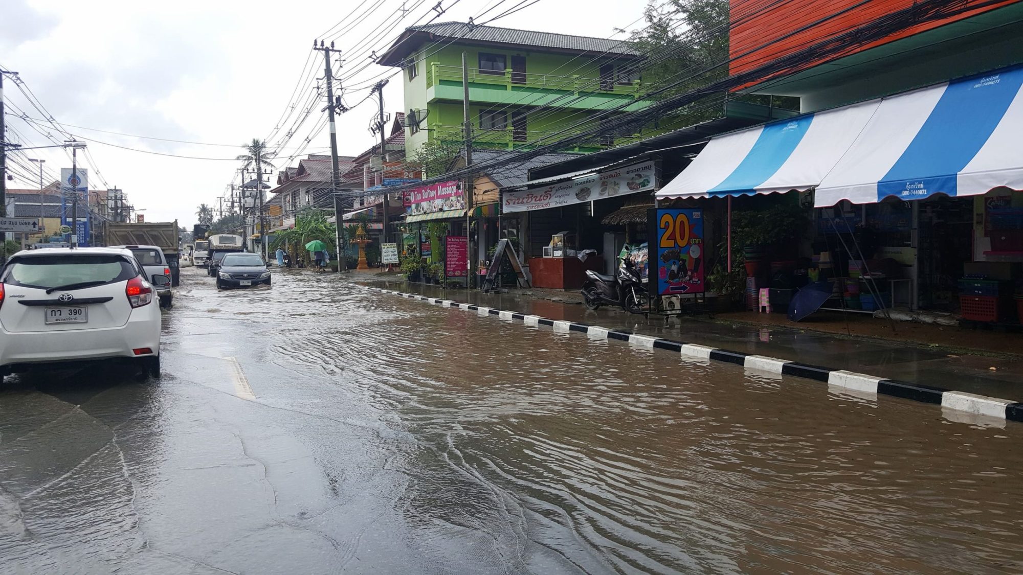 泰國市區降雨後道路局部積水與行駛車輛
