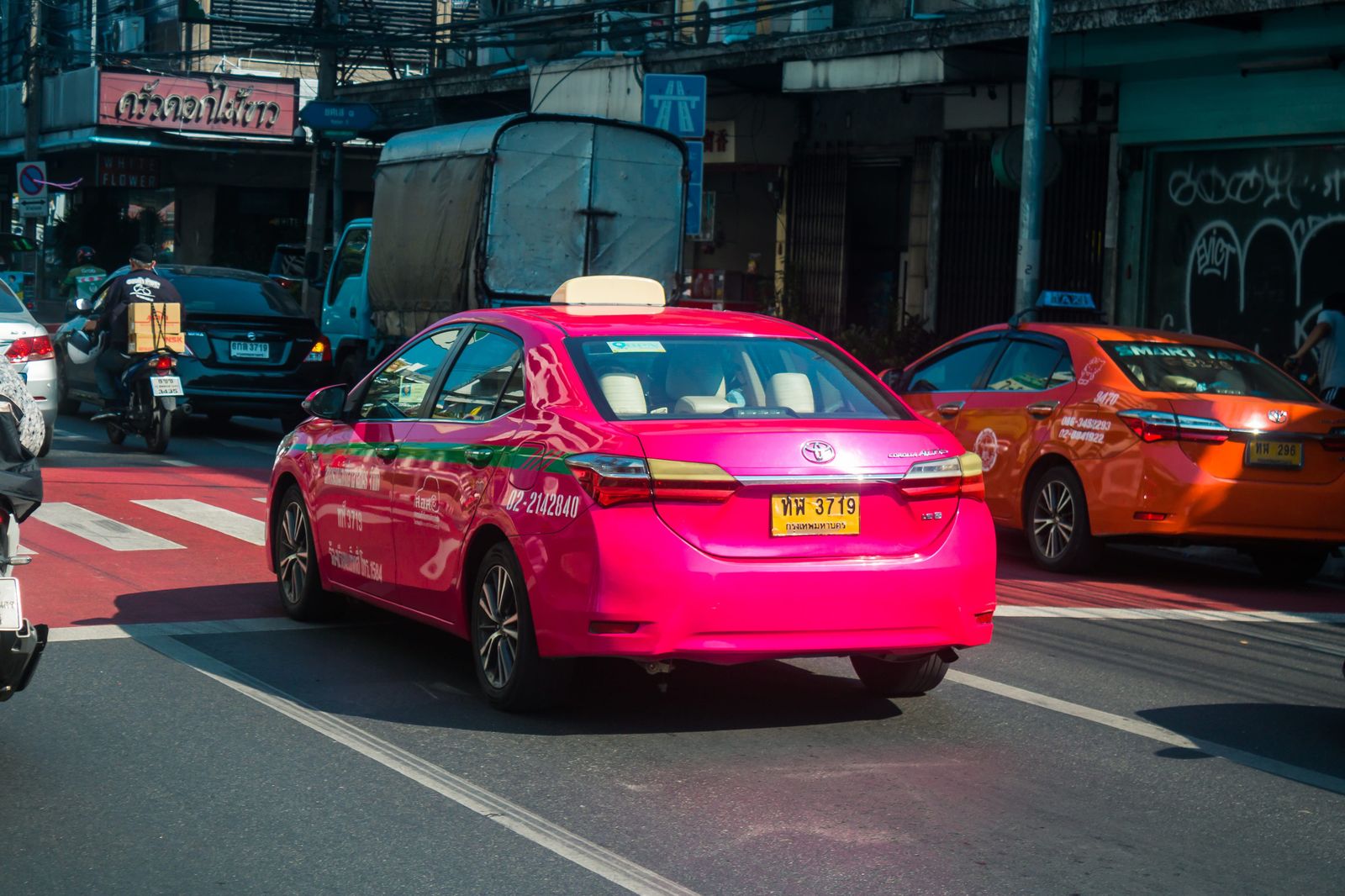 曼谷粉紅色跳表計程車與黃色營業車牌