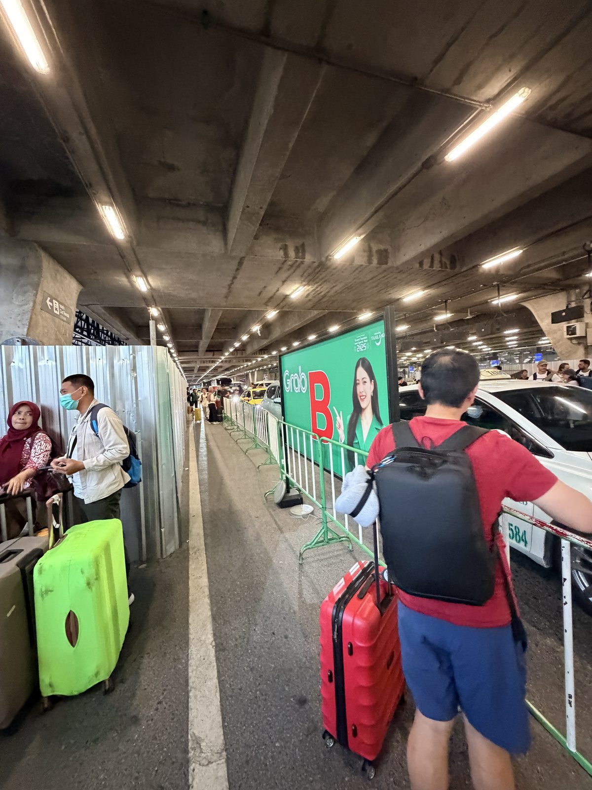 素萬那普機場 Grab 服務區的候車車輛與攜帶行李旅客