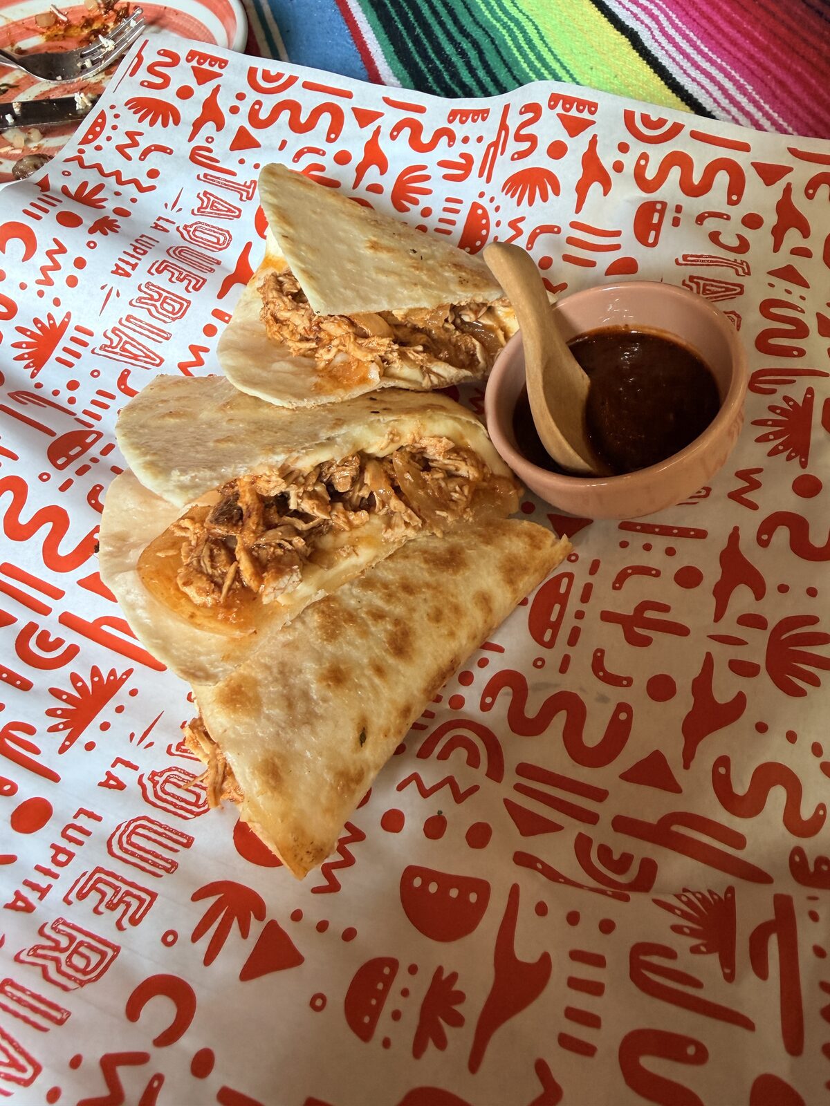 切成三角形的 Tinga 雞肉起司夾餅，內餡是雞肉絲與紅色醬汁