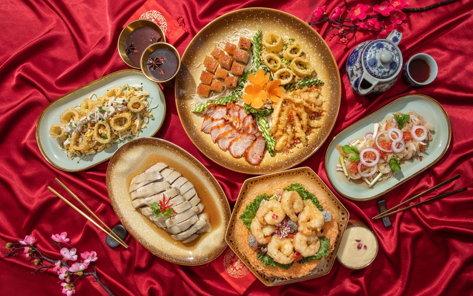 紅色桌布上擺著叉燒、白切雞、炸魷魚與炸蝦等中式菜餚