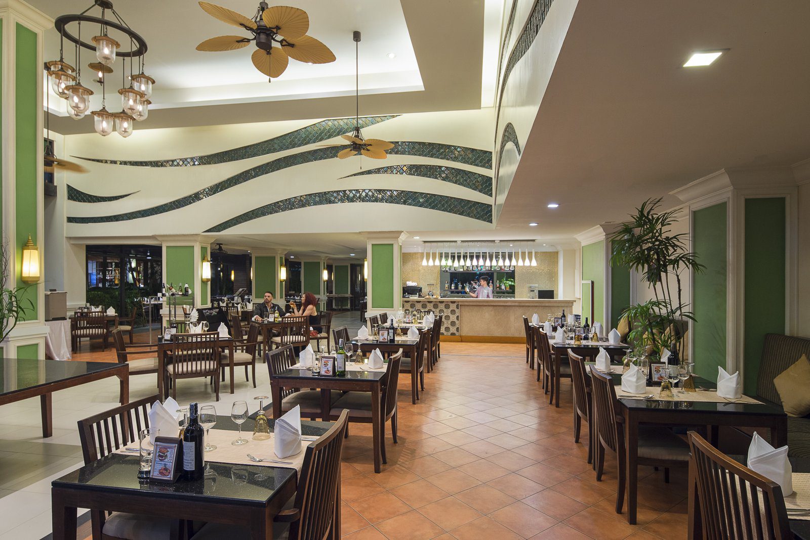 Palm Court 餐廳裡的木桌椅，天花板掛著吊扇與燈飾