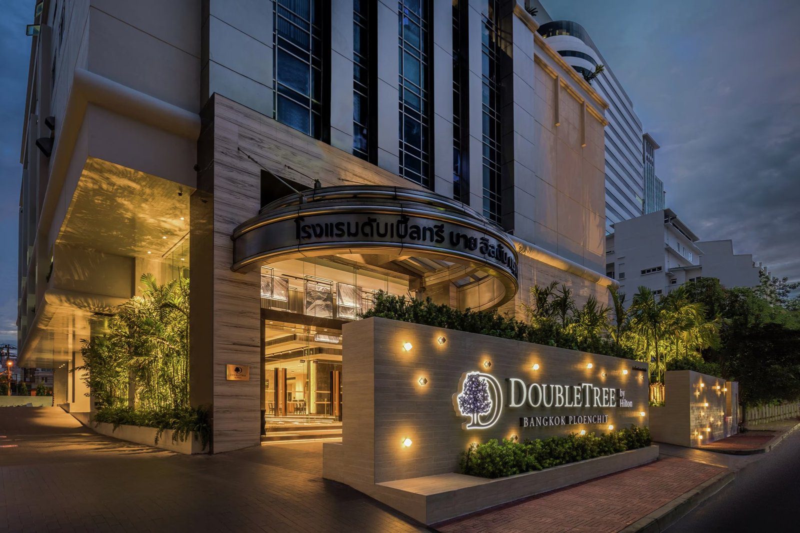 傍晚的飯店入口，門前有弧形雨遮與 DoubleTree 招牌