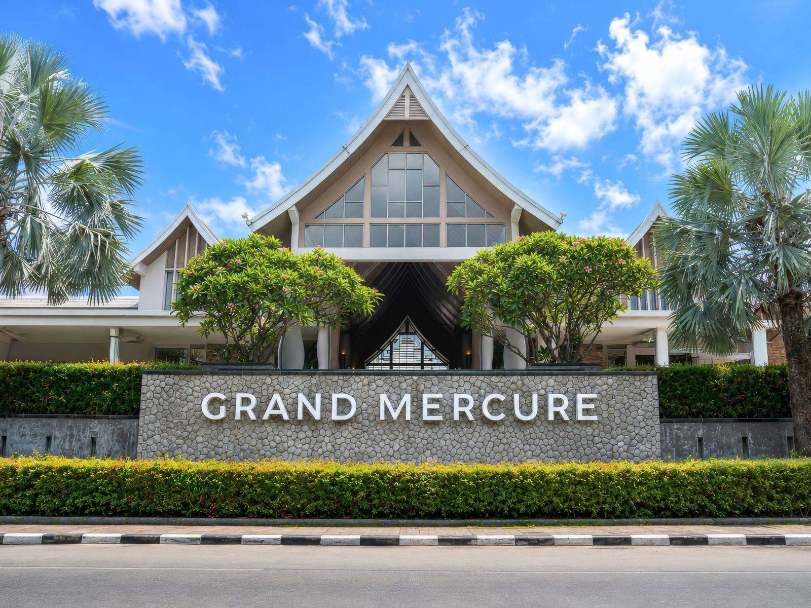 度假村入口的 GRAND MERCURE 招牌牆與尖頂建築