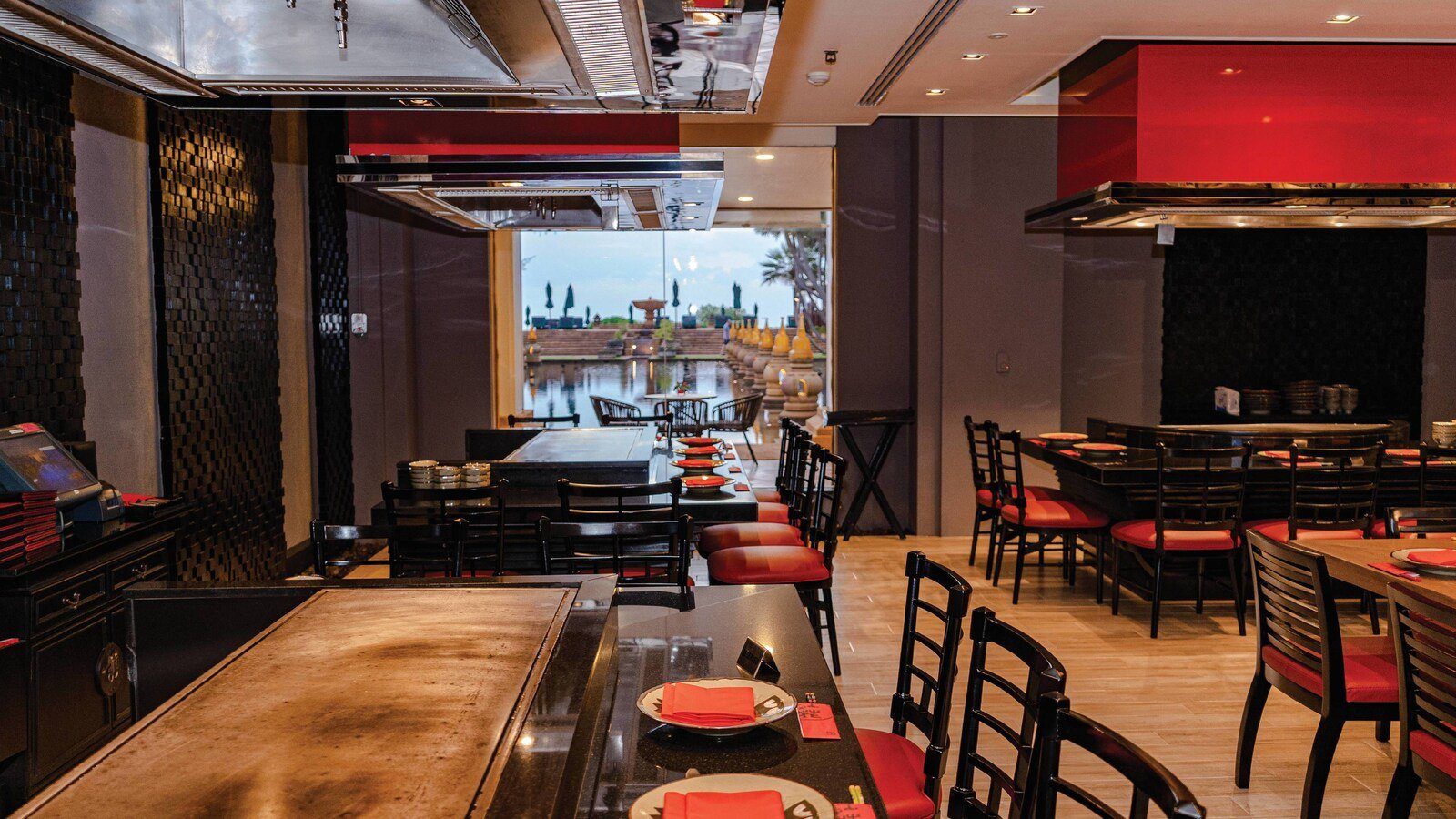 Benihana 餐廳裡的鐵板燒吧台與紅色吊燈，後方是一排落地窗