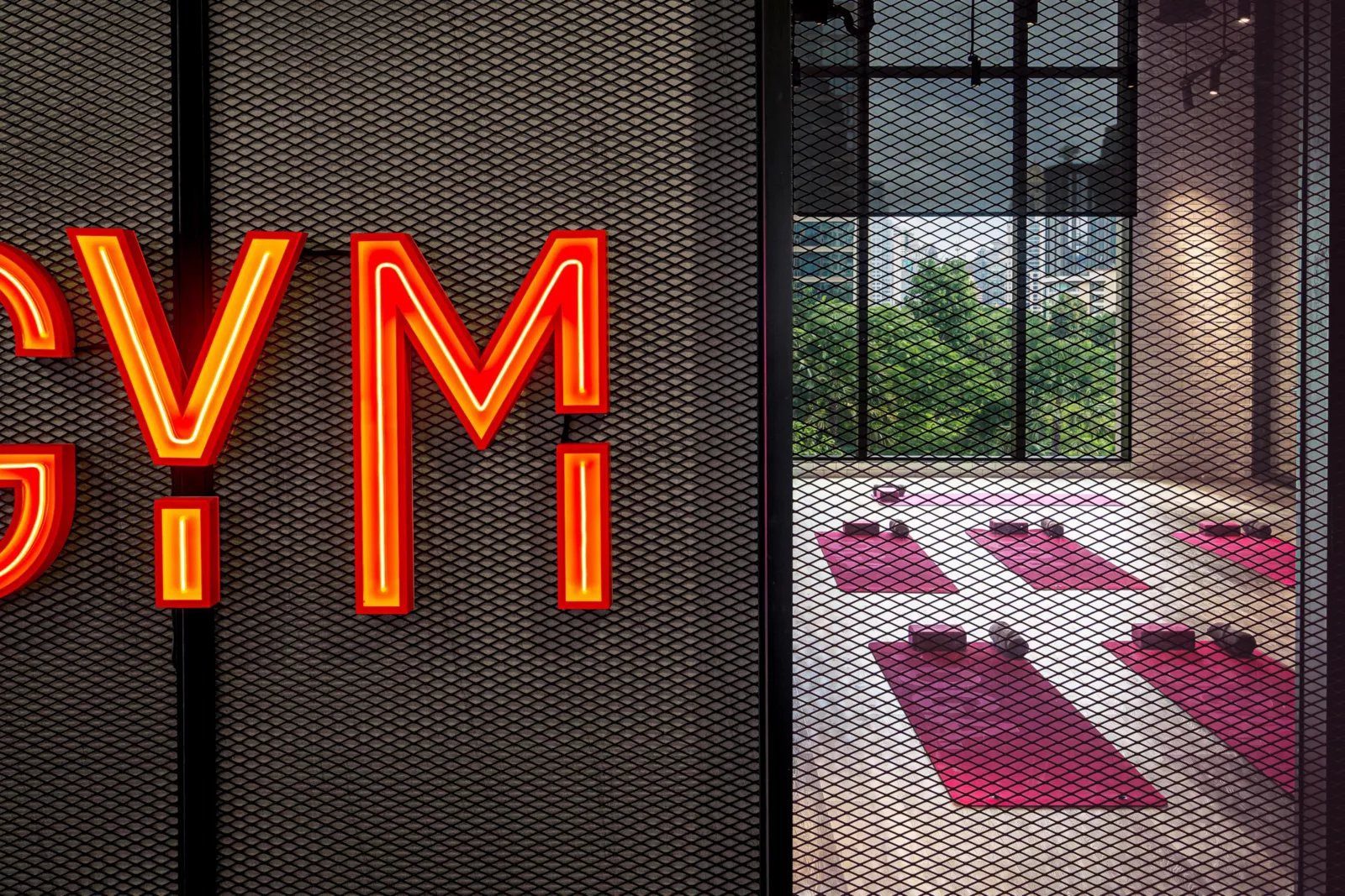 曼谷 Kimpton Maa-Lai 酒店 健身中心的霓虹 GYM 字樣與器材