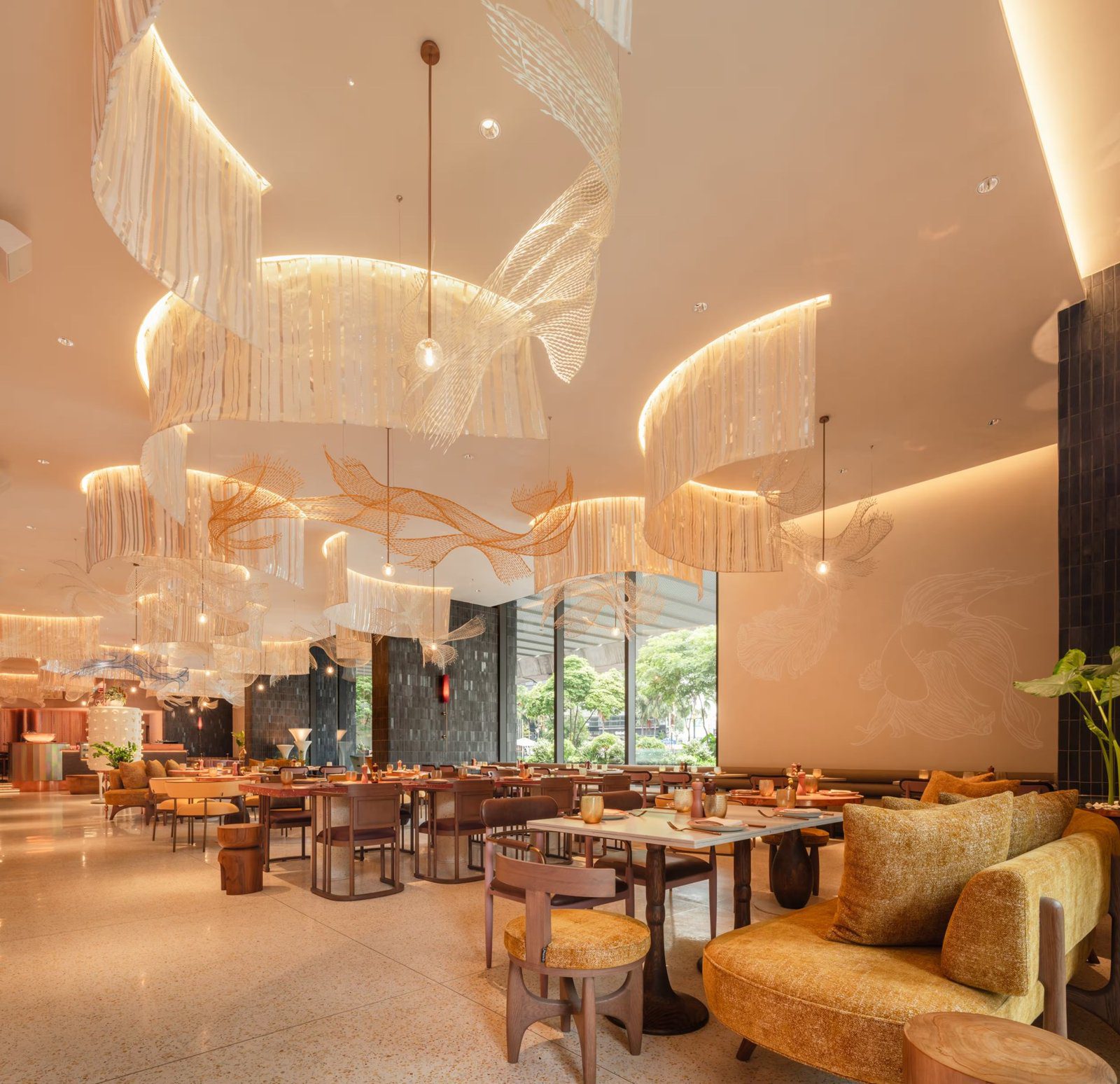Colette 餐廳挑高天花板垂掛波浪狀燈飾，擺著餐桌與黃色沙發