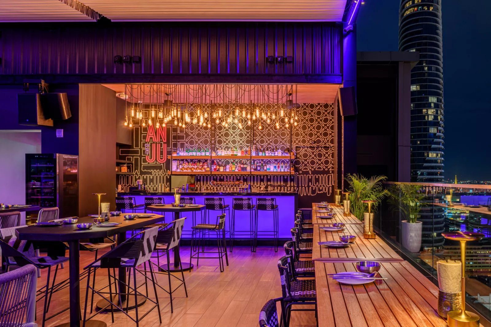 曼谷盛鴻中城酒店 ANJU 屋頂酒吧的霓虹吧台與曼谷夜景