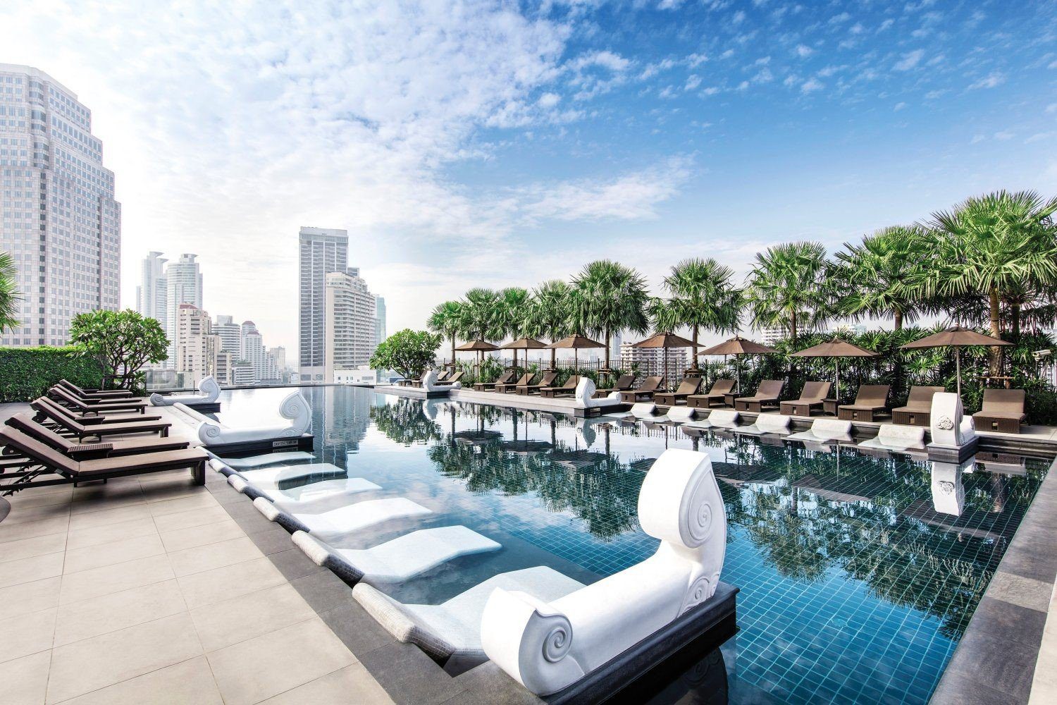 棕櫚樹環繞的戶外無邊際泳池與躺椅（圖：Grande Centre Point Terminal 21 Bangkok／官網）