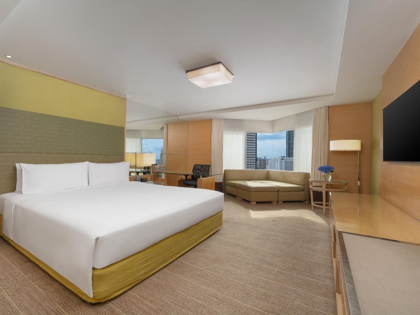 大床客房與窗邊沙發區（圖：Holiday Inn Bangkok Silom／官網）