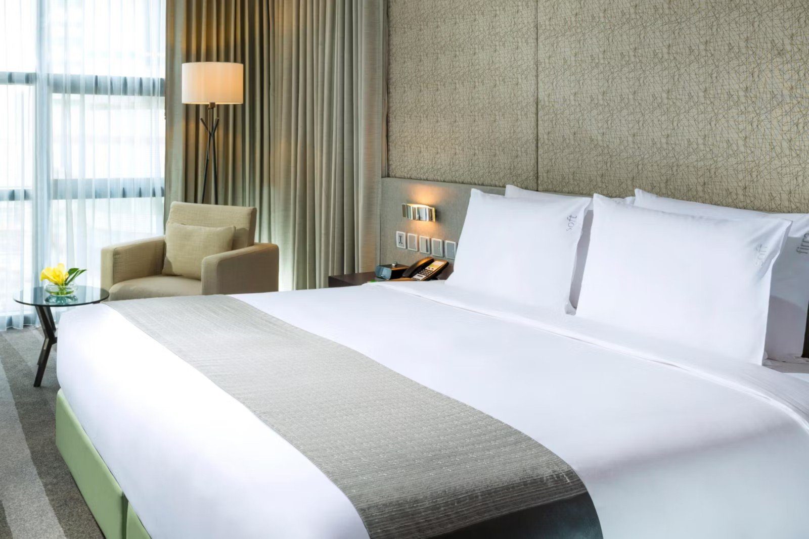 大床客房床鋪與窗邊單椅（圖：Holiday Inn Bangkok Sukhumvit／官網）