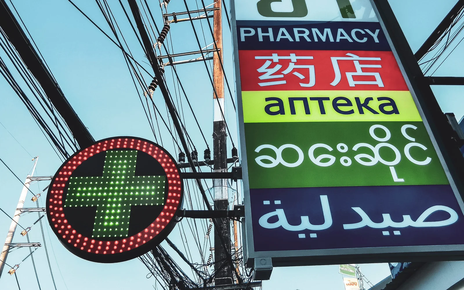 泰國觀光區藥局 Pharmacy 綠色十字燈箱與多語招牌門市外觀
