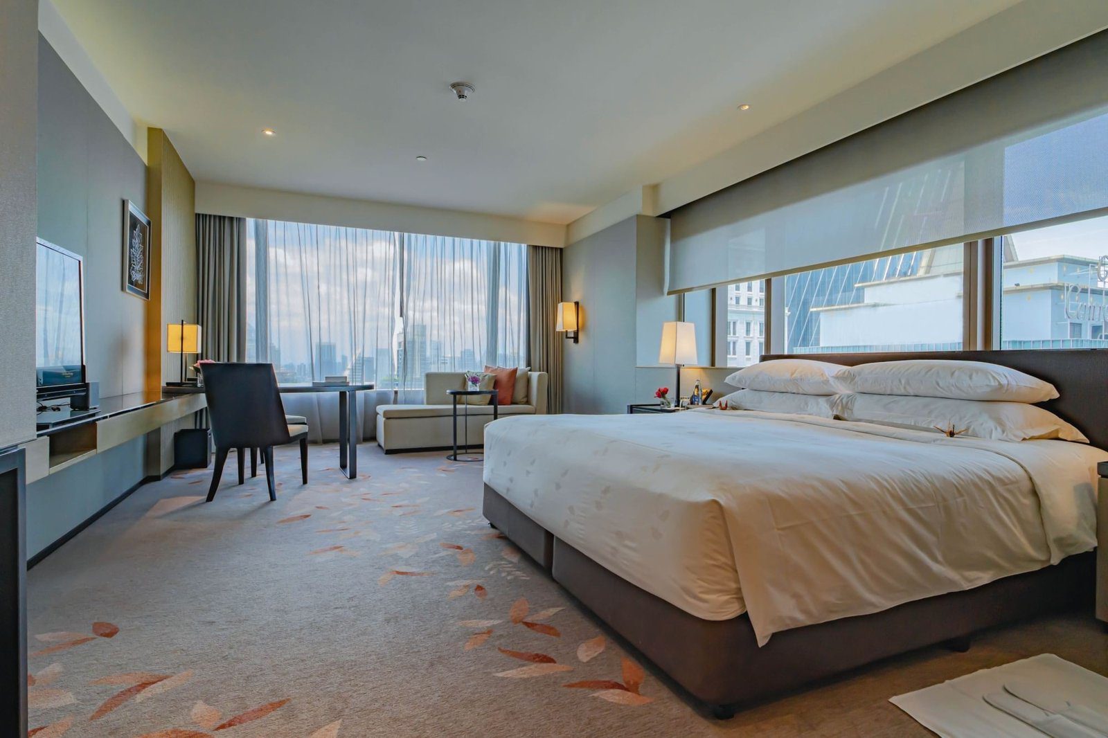 Deluxe 轉角客房大床與窗景（圖：The Okura Prestige Bangkok／官網）